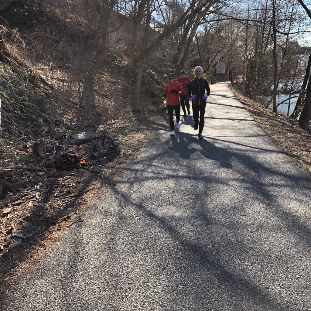 Three distant runners on a canal towpath