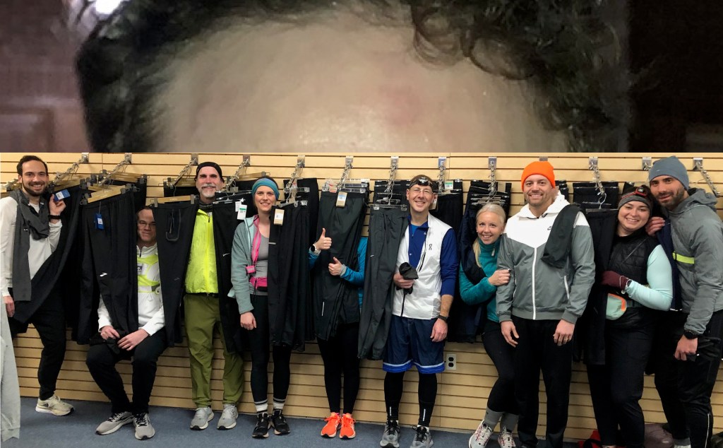 Runners nestled amid hangers of long running pants with enlarged image of forehead pasted above.