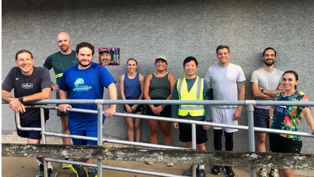 Runners lined up side to side in front of outside wall of store