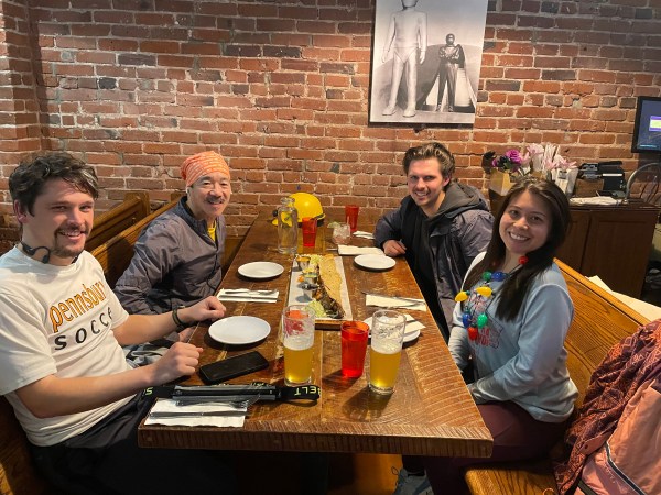 4 runners seated around a table with a extra-long fajita in the center