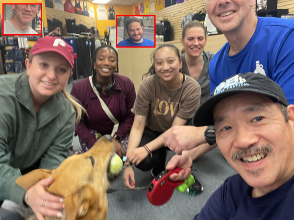 A bunch of runners crouching around dog Nico with the tops of some heads visually missing