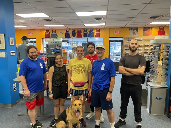 Runners standing. Dog sitting.