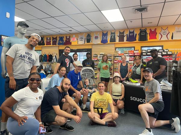 15 people around a little girl in a running stroller